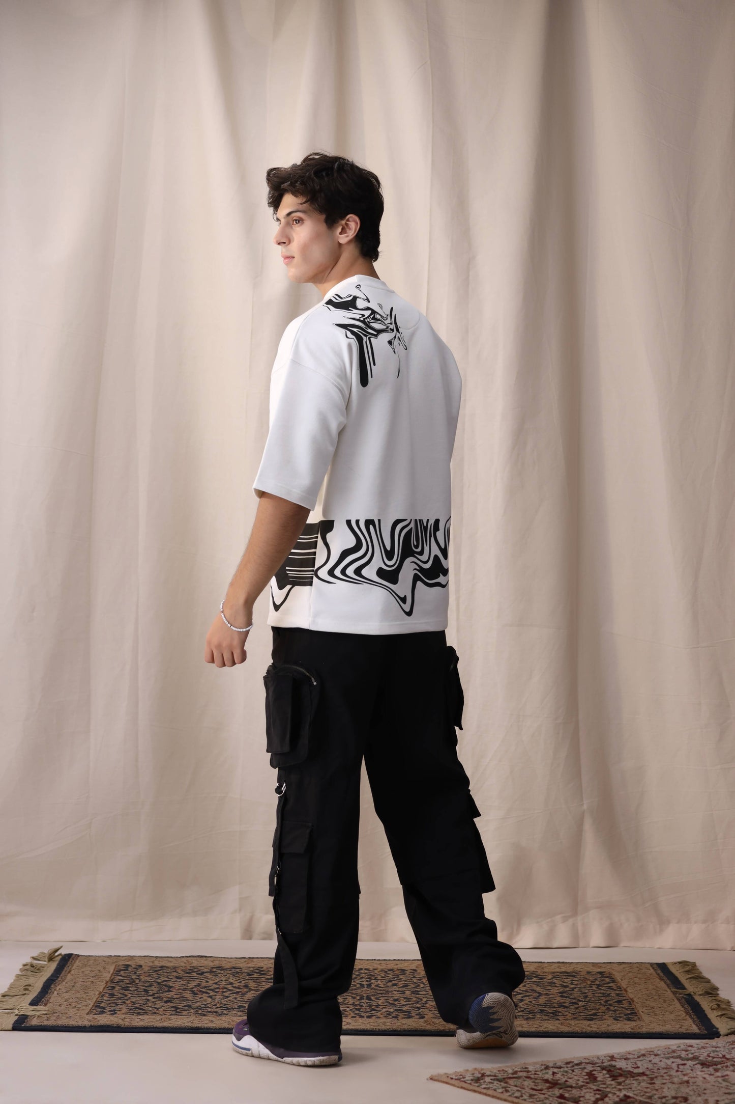 Model wearing Bisaat white oversized drop shoulder unisex t-shirt by Shatrnj