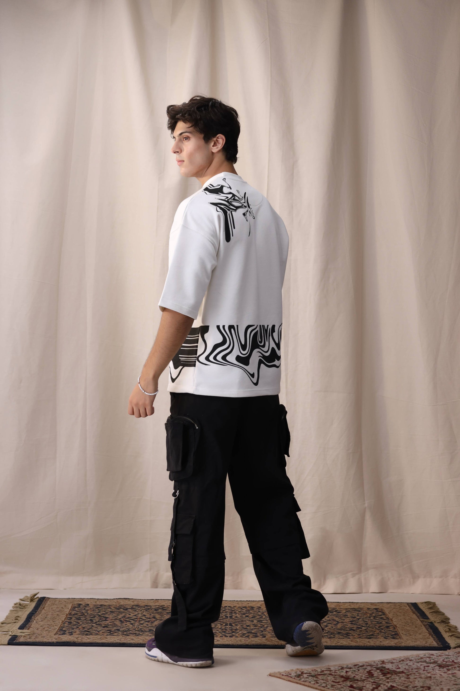 Model wearing Bisaat white oversized drop shoulder unisex t-shirt by Shatrnj