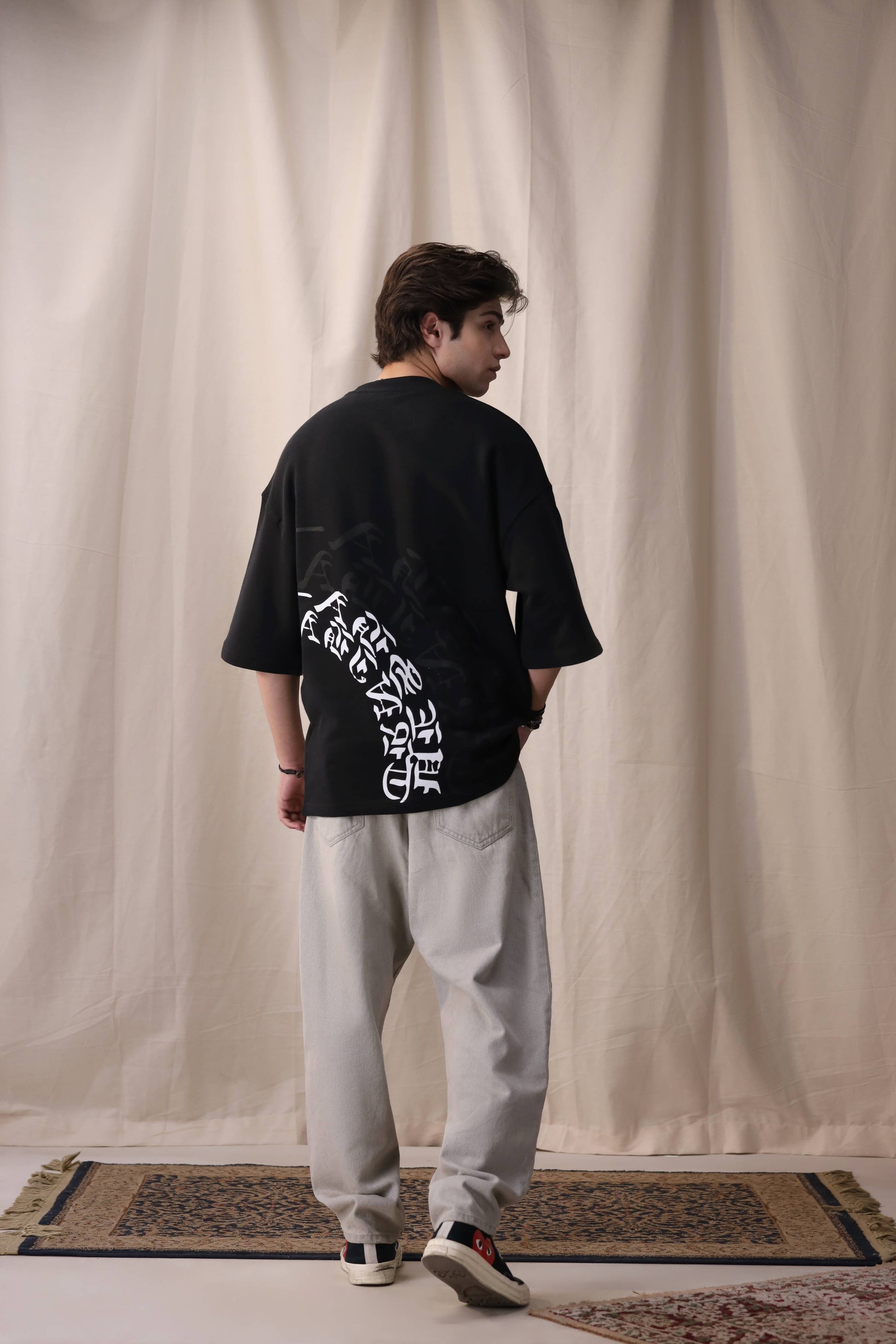 Model wearing Arkaan black oversized drop shoulder unisex t-shirt by Shatrnj