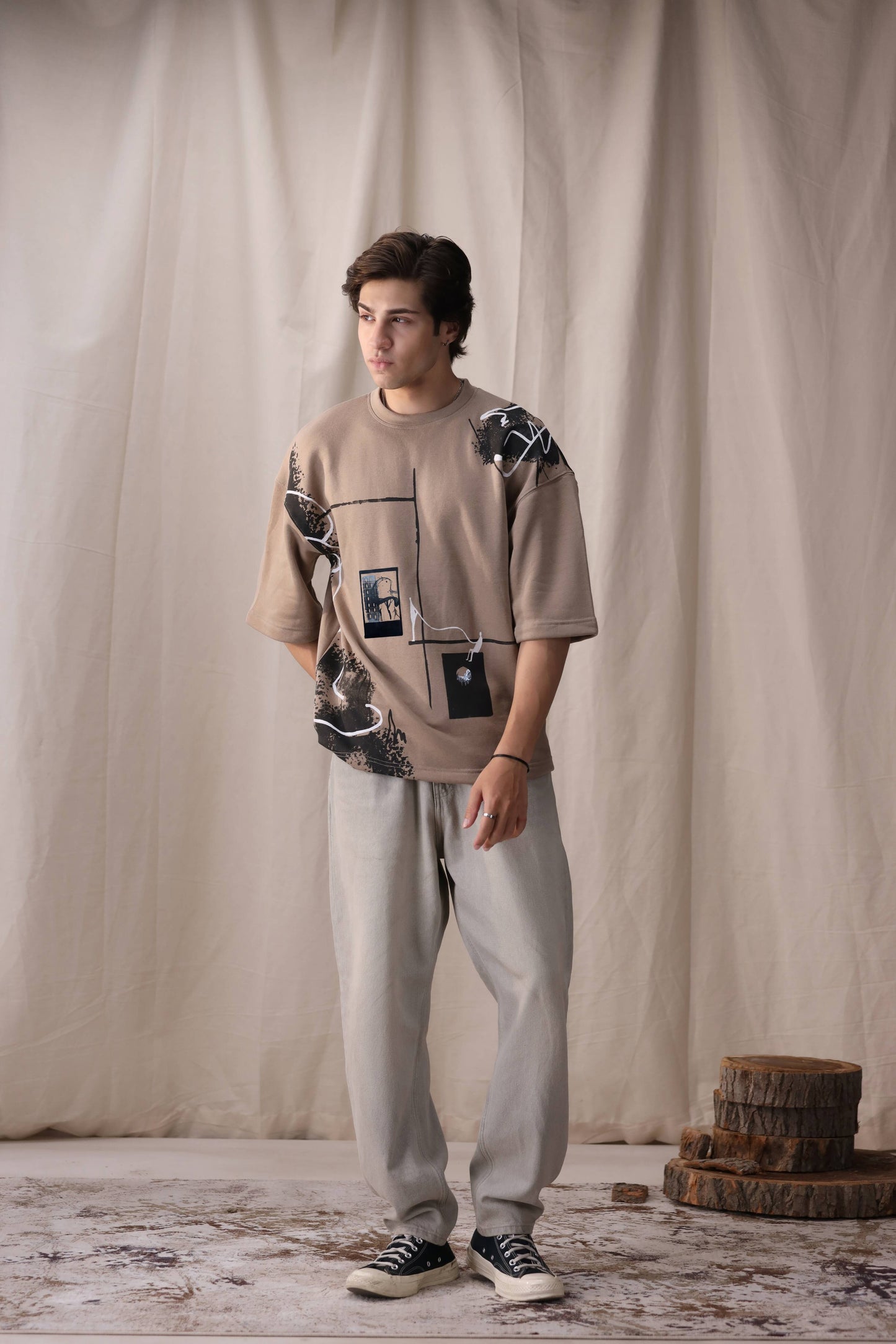 Model wearing Rukn beige oversized box fit unisex t-shirt by Shatrnj