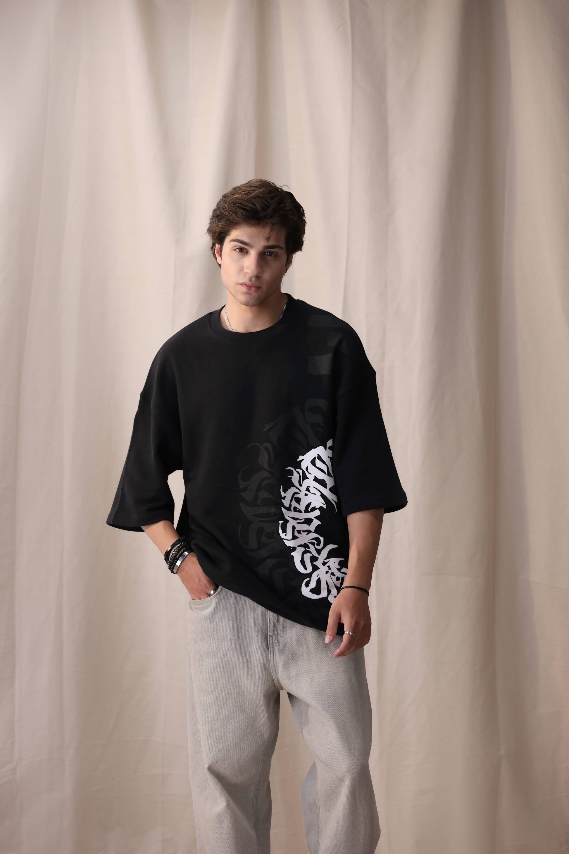 Model wearing Arkaan black oversized drop shoulder unisex t-shirt by Shatrnj