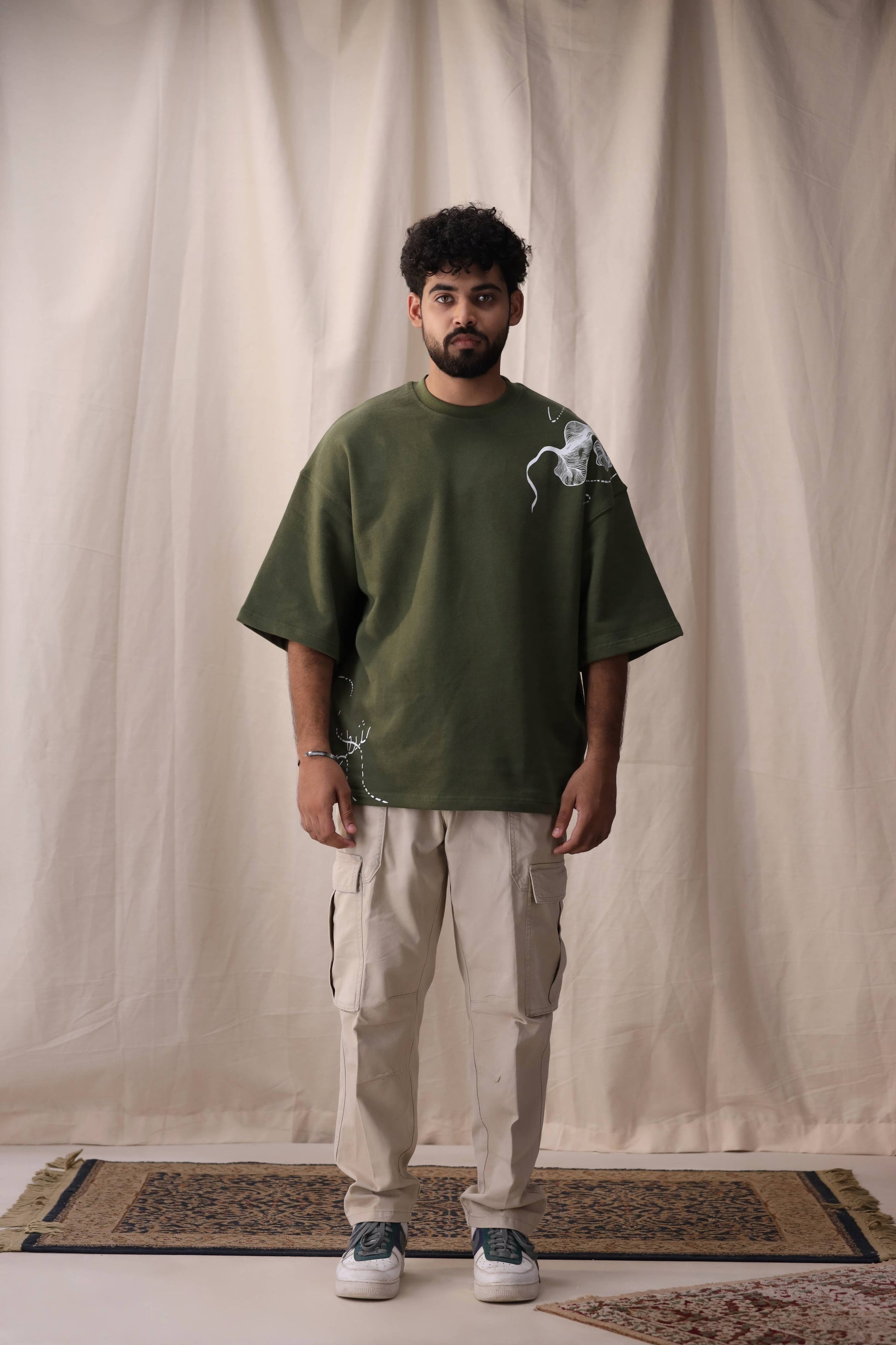 Model wearing Cartela olive green oversized drop shoulder unisex t-shirt by Shatrnj
