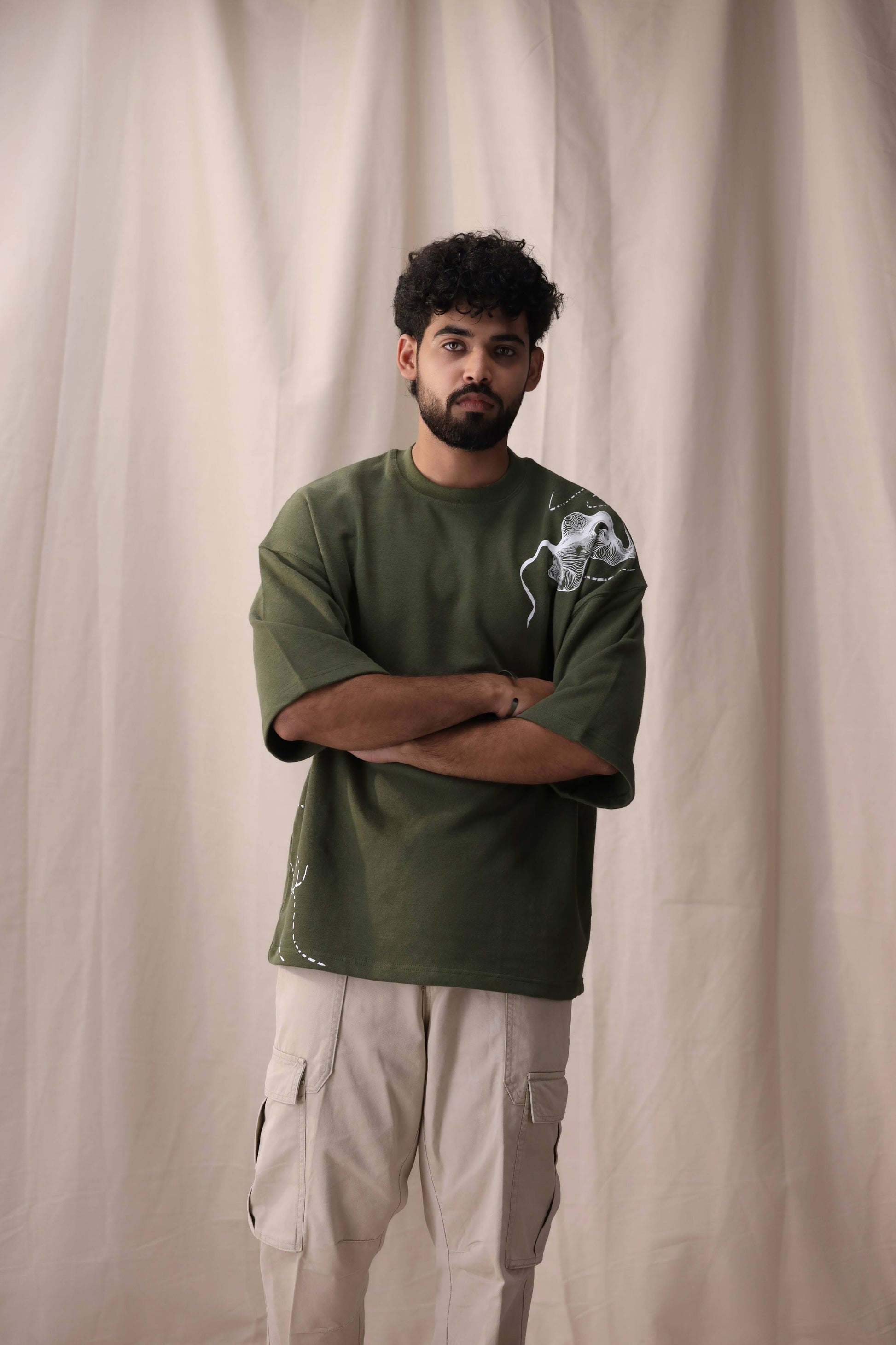Model wearing Cartela olive green oversized drop shoulder unisex t-shirt by Shatrnj